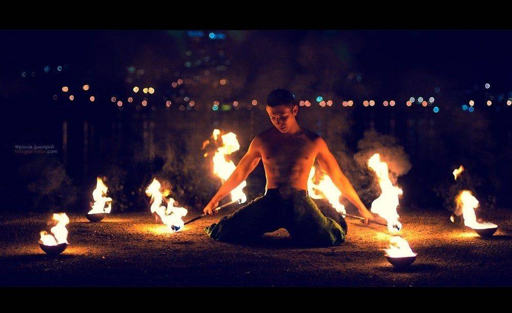 ภาพพอร์ตเทรตแสงไฟสุดดราม่า: ผู้ชายแสดงท่าทางข้างวงไฟระหว่างเซสชั่นถ่ายภาพที่เข้มข้น
