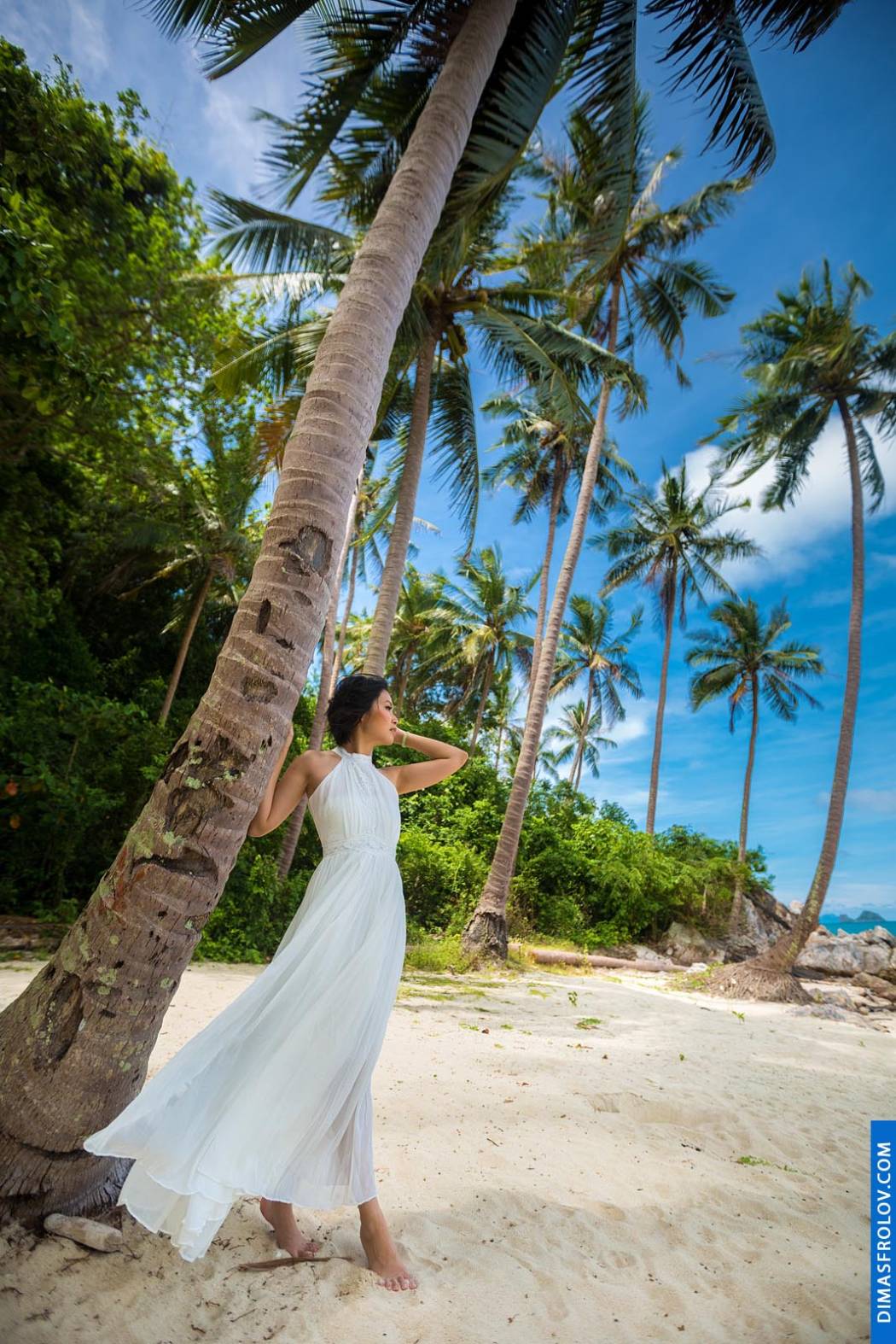หญิงสาวในชุดขาวบางเบาดั่งเทพธิดาพักผ่อนใต้ต้นปาล์ม