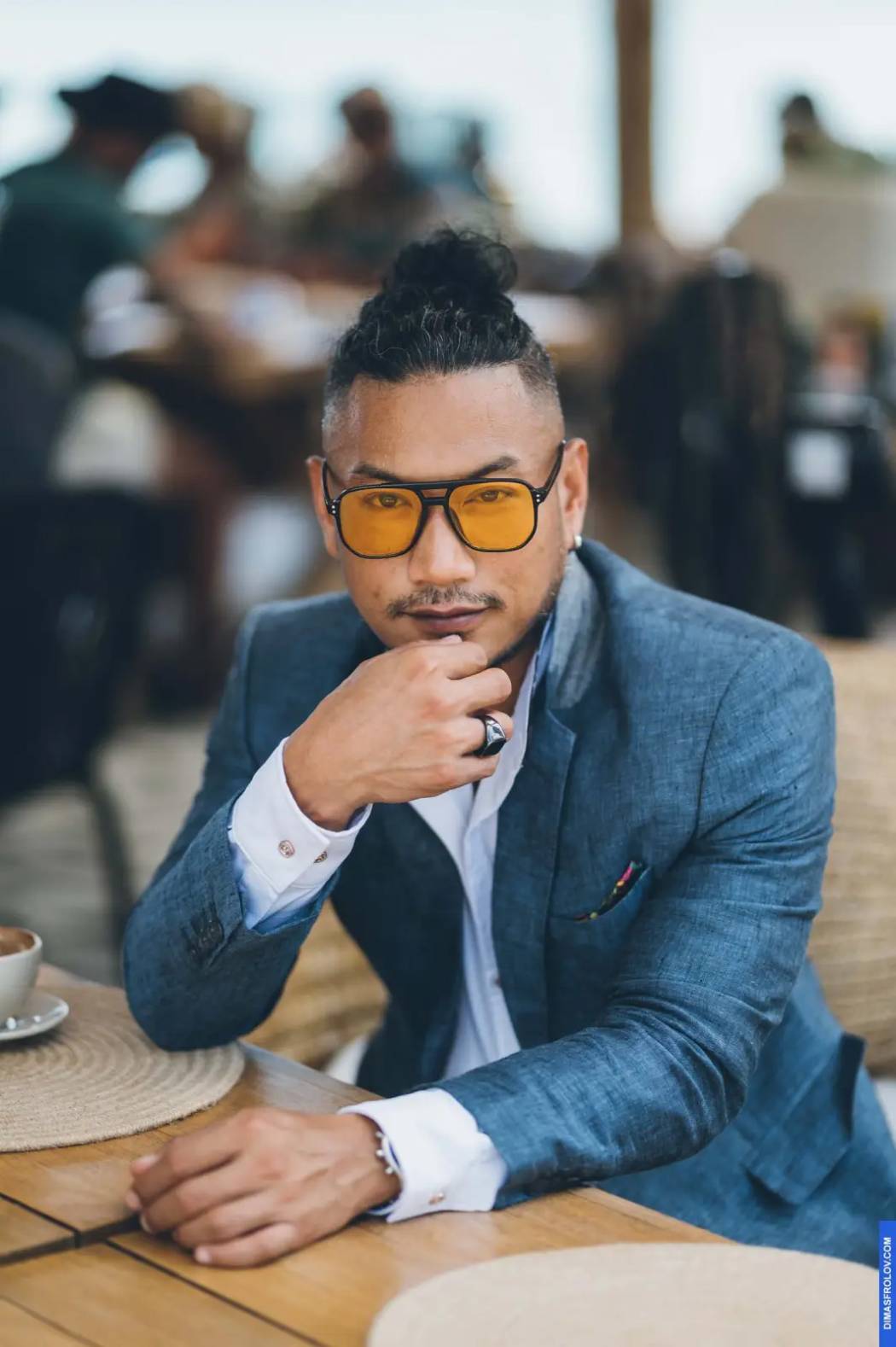 Stylish male portrait at cafe in blue suit and yellow sunglasses