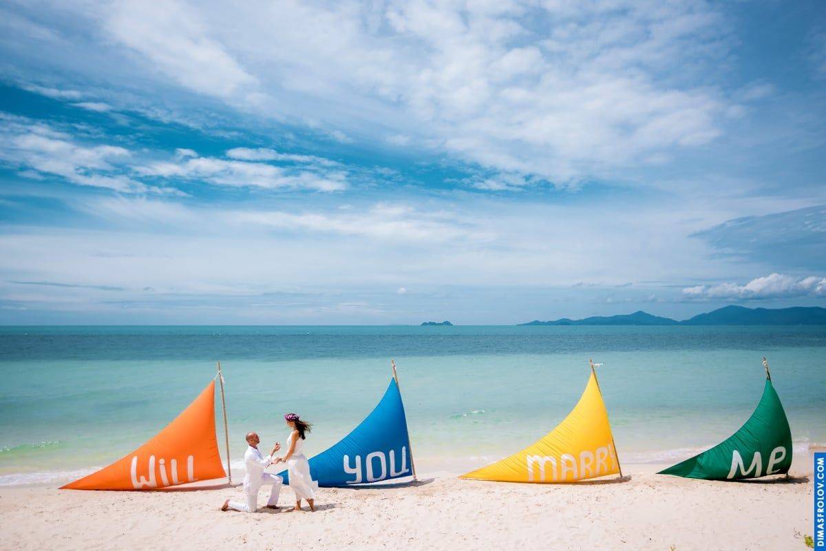 Will you merry me. Creative beach proposal setup with vibrant sails