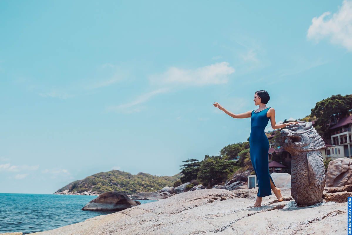Casual portrait of a woman in blue jumpsuit at rocky beach with sea horizon