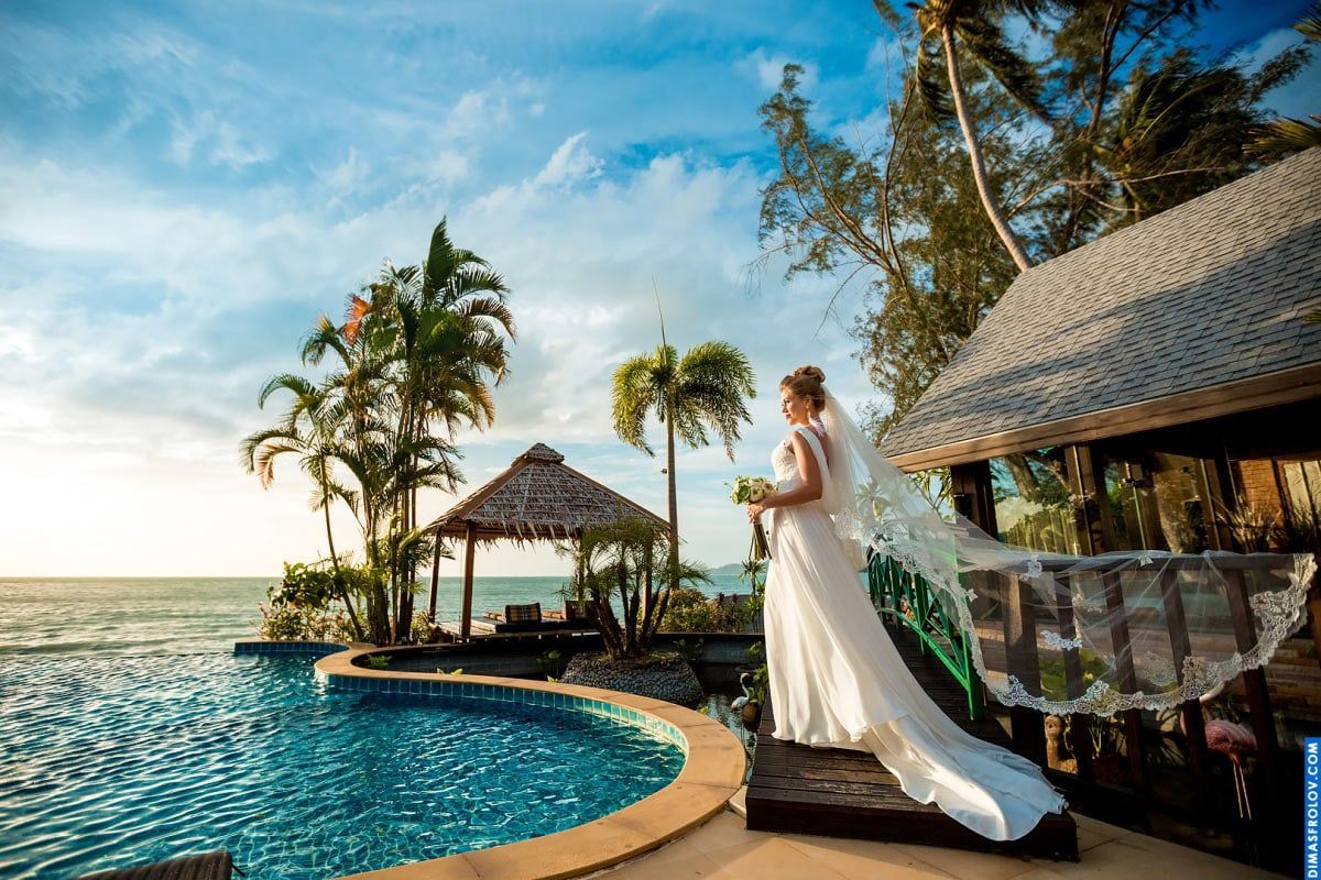 Bride by the pool with veil flowing in the breeze — elegant tropical wedding vibe