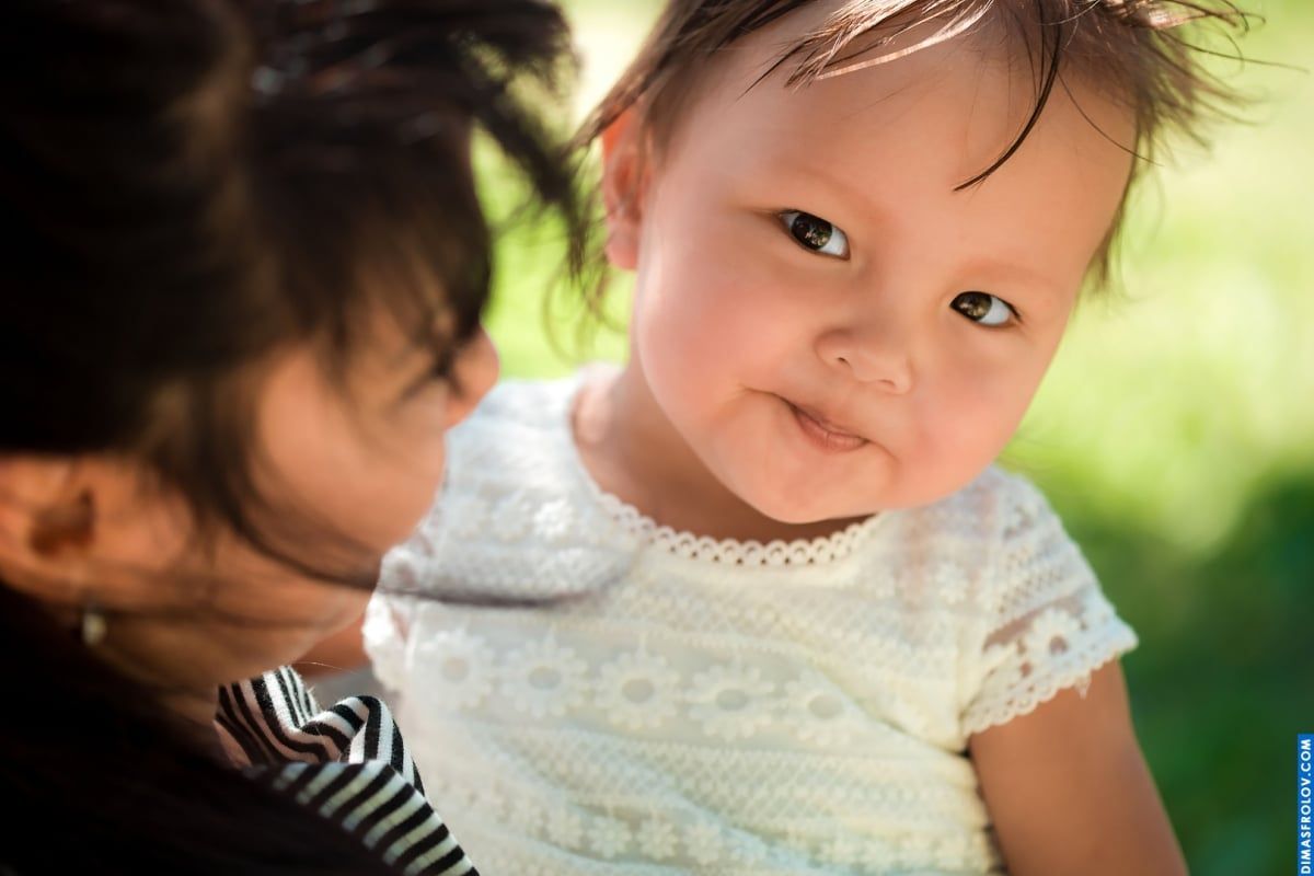 Retrato de bebê doce — close-up com um sorriso suave nos braços da mamãe