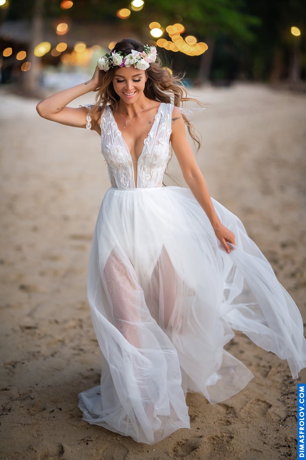 Bride walking along the beach in soft evening light