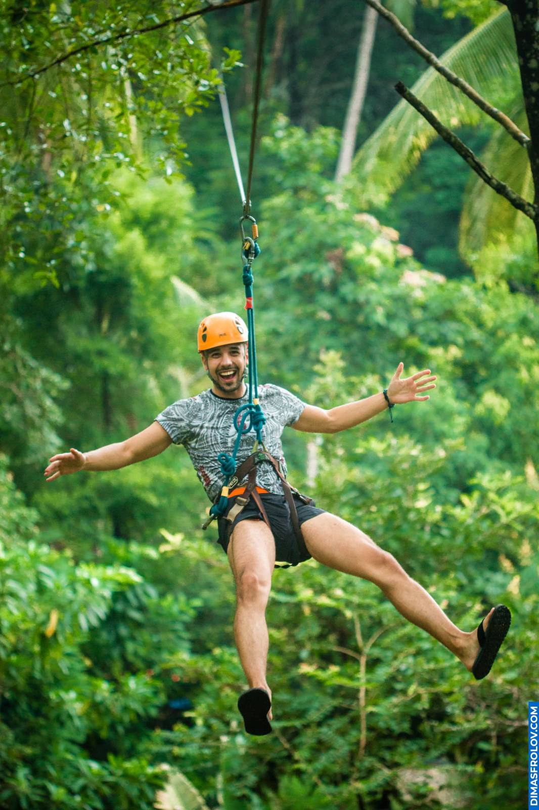 Adventurer enjoying a jungle zipline ride wearing helmet and harness