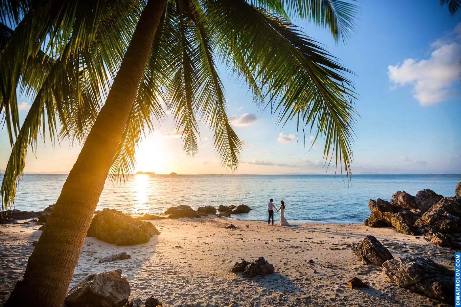คู่แต่งงานเดินเล่นริมชายหาดยามพระอาทิตย์ตก