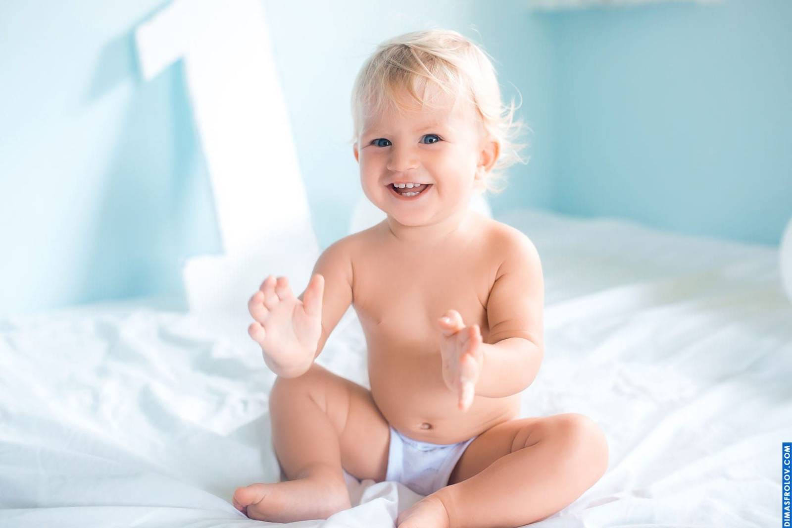 Baby portrait on 1st birthday — joyful photo shoot with “1” backdrop