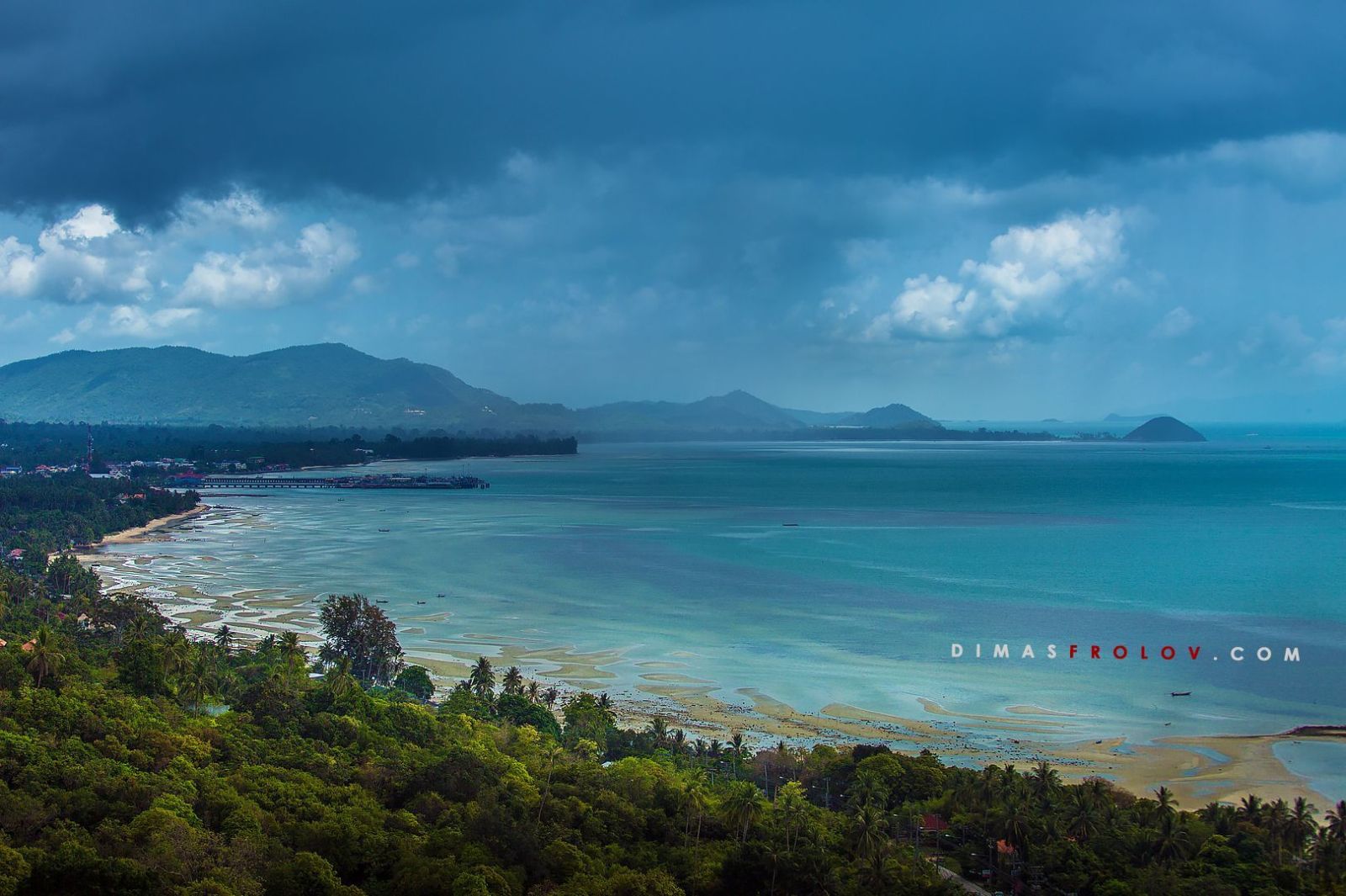 Dramatic seascape with dark clouds and a small opening showing a strip of light on the horizon