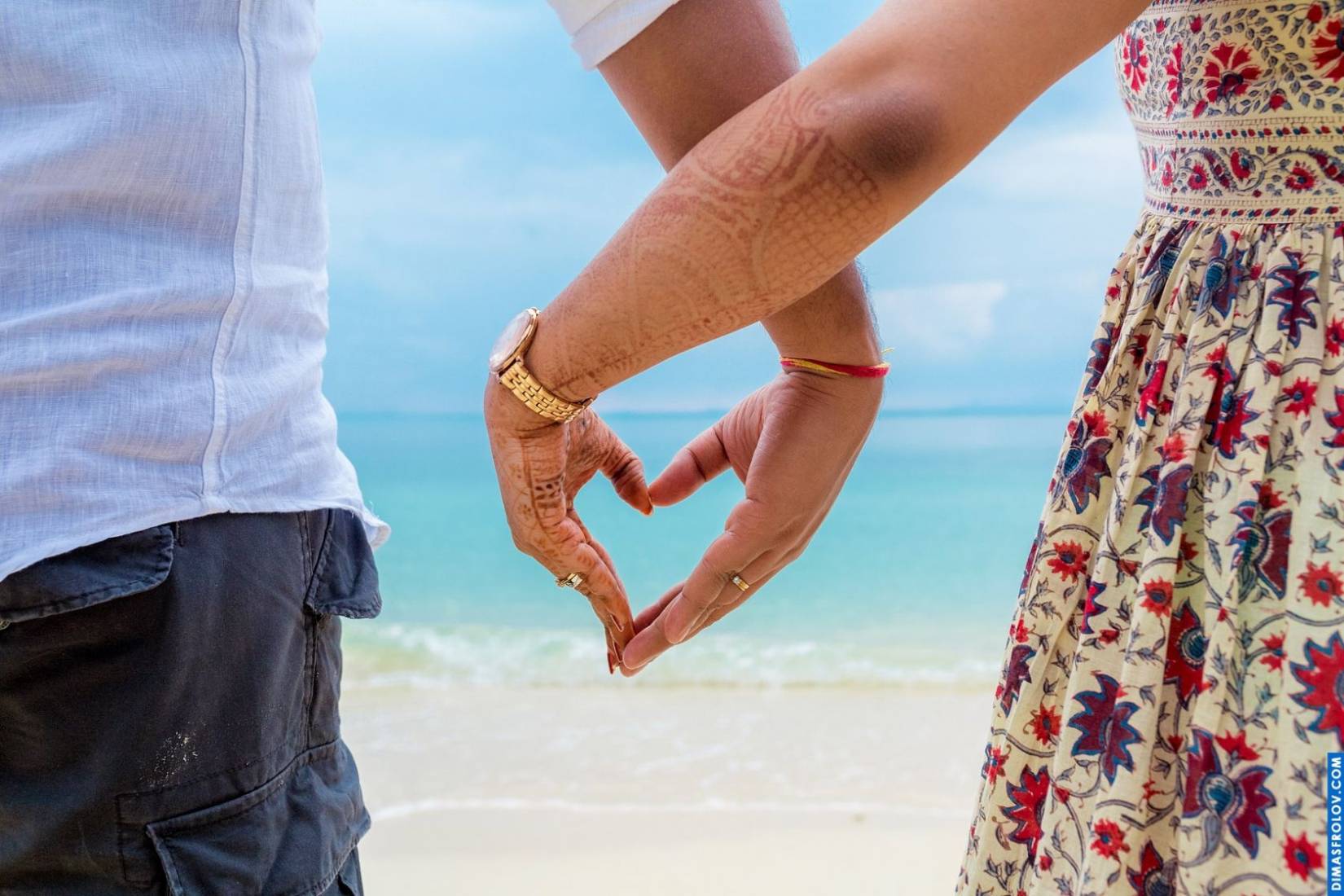 Creative heart shape formed by hands on the beach