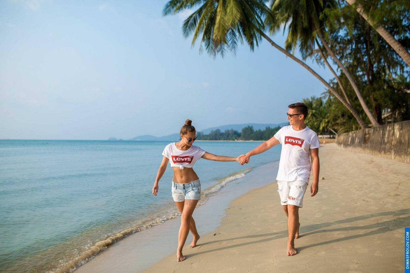 คู่รักใส่เสื้อคู่ เดินเล่นริมชายหาดอย่างสนุกสนาน