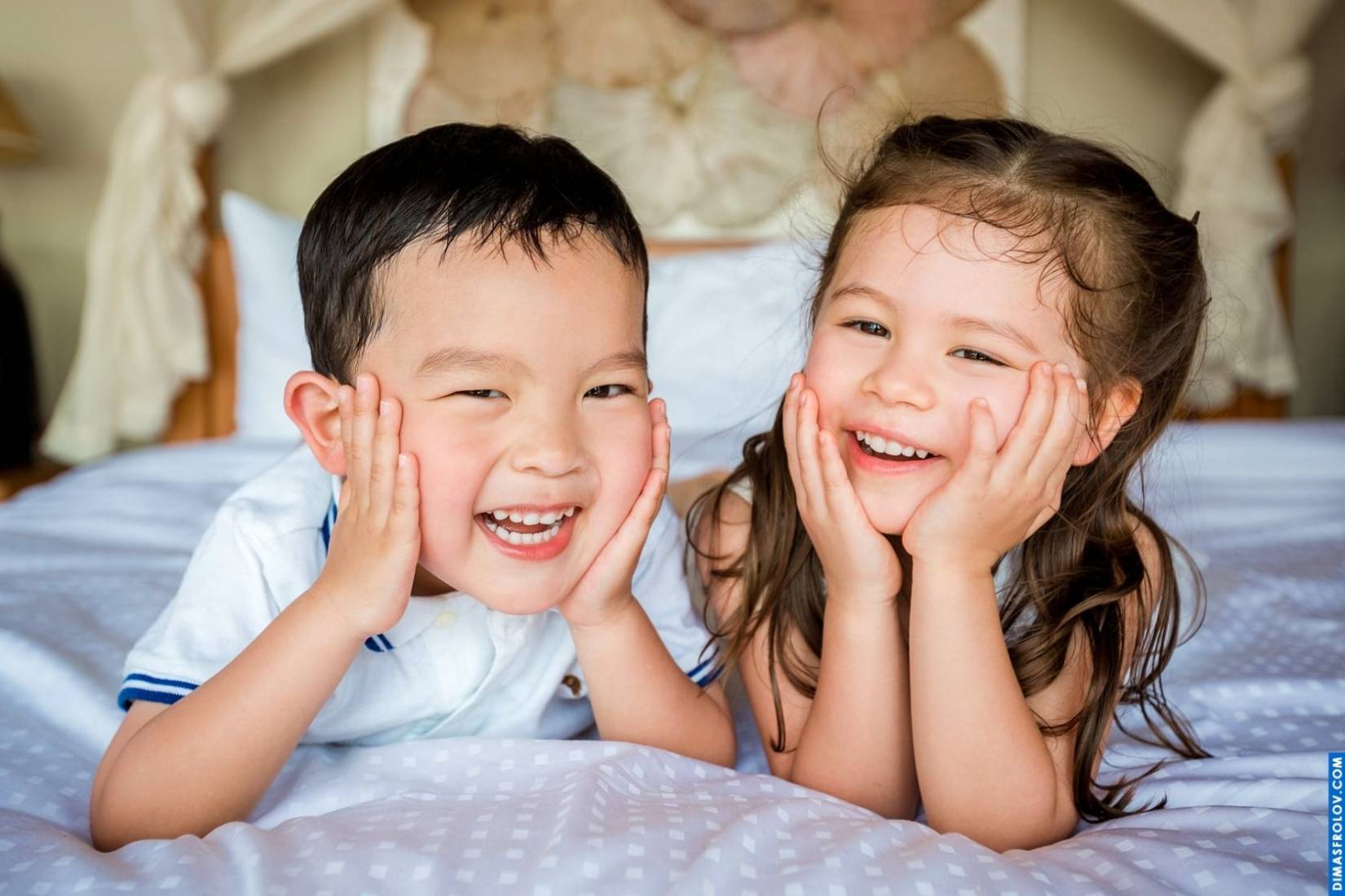 Studio-style portrait of siblings on the bed — fun and adorable kids photo