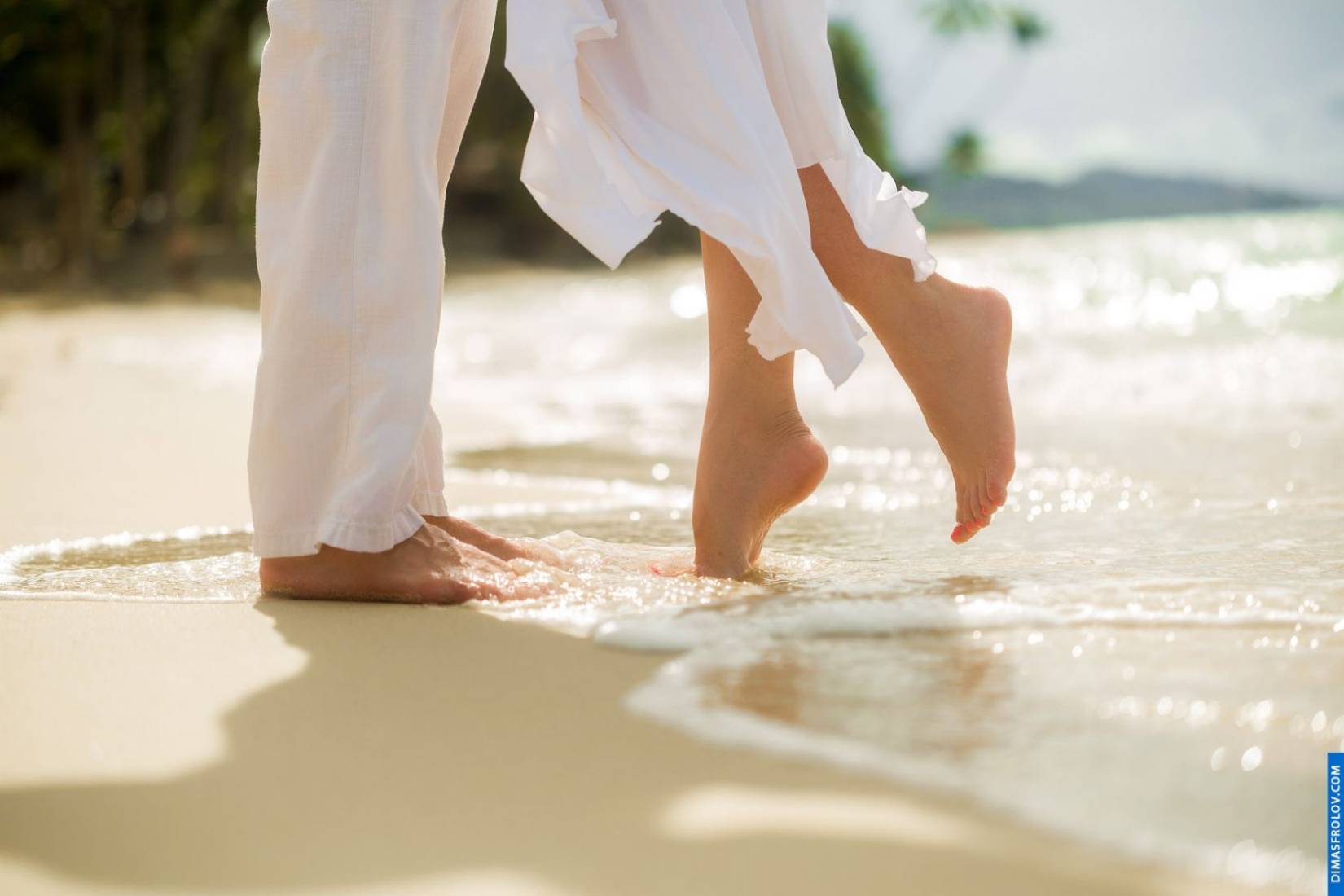 ภาพเท้าใกล้ๆ ของคู่รักเดินริมชายหาด