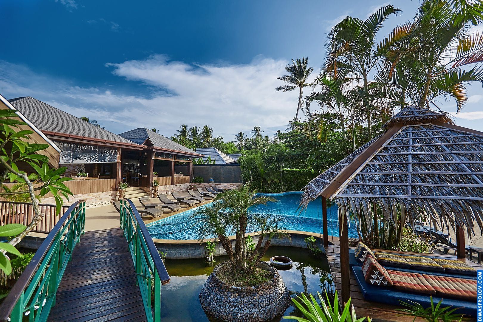 Luxury resort exterior: elegant villas and lush tropical gardens by the pool