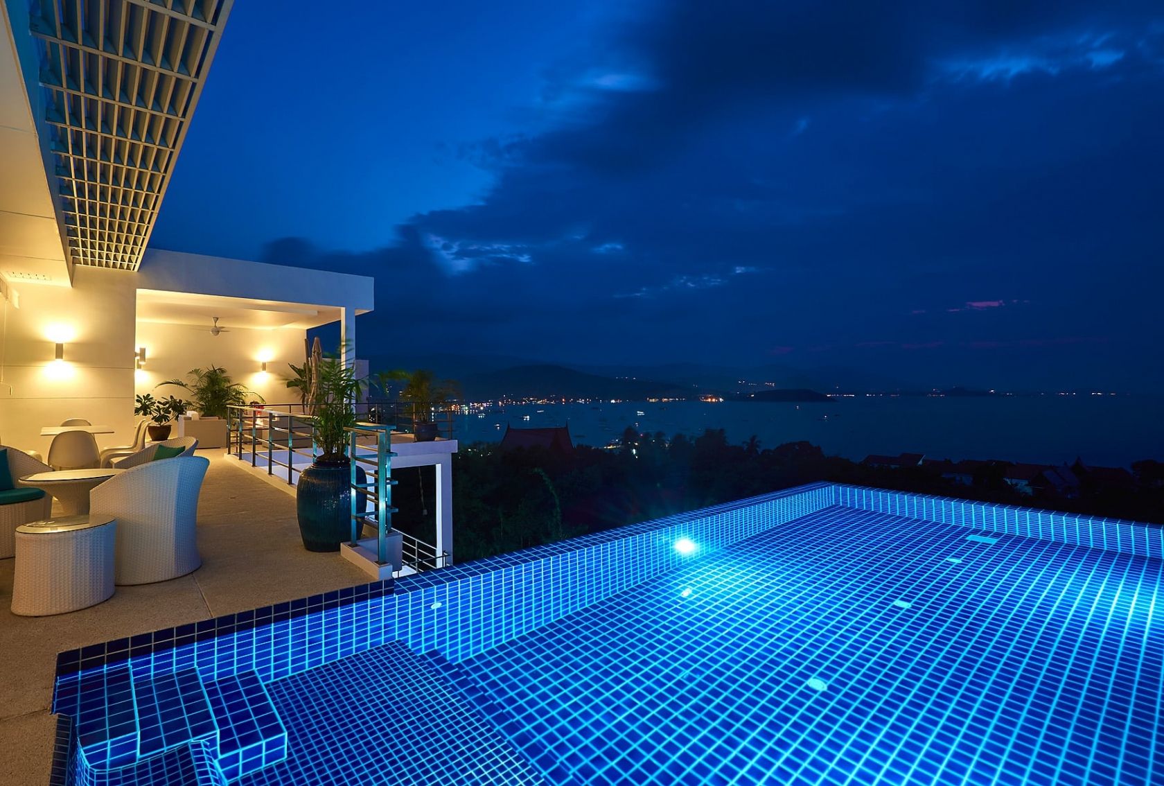 Twilight infinity pool: modern villa reflecting in the illuminated water at dusk