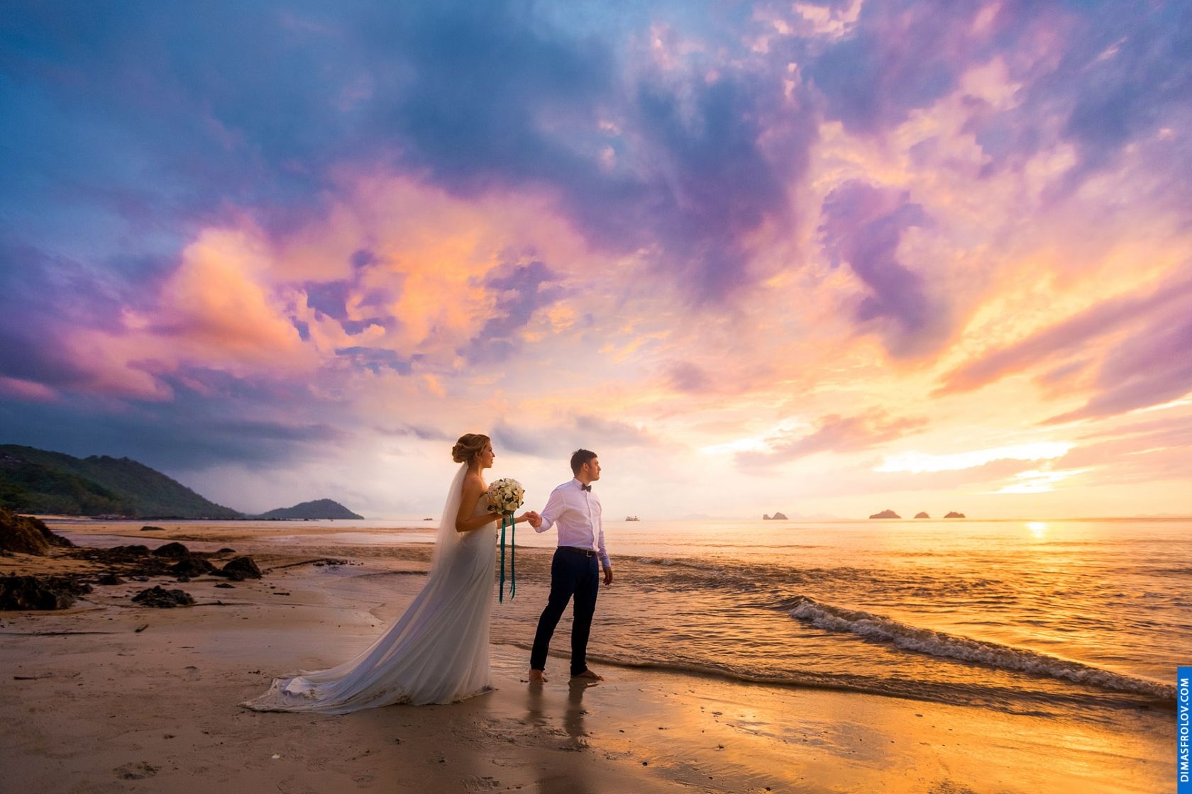 Wedding couple walking at sunset under dramatic sky