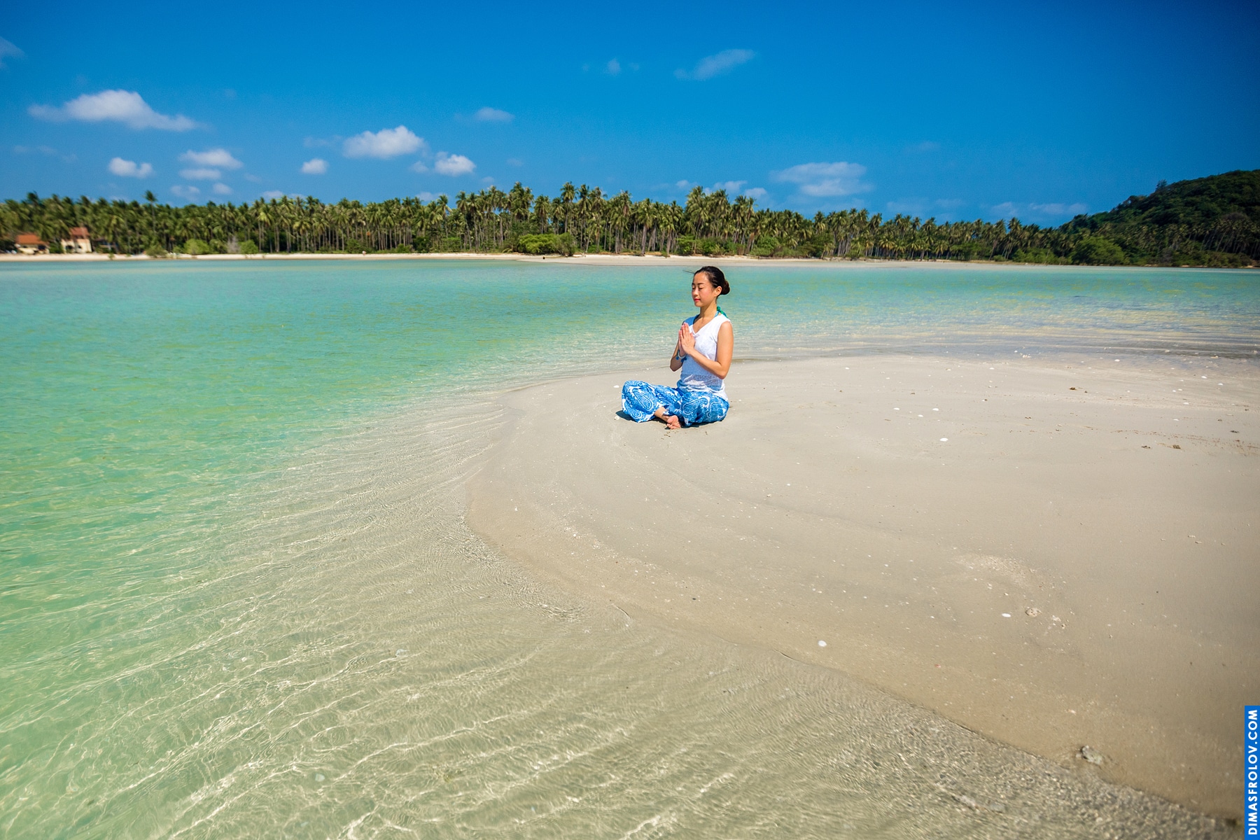 Tropical beach with clear turquoise water and a person standing in the distance, enjoying the serene view
