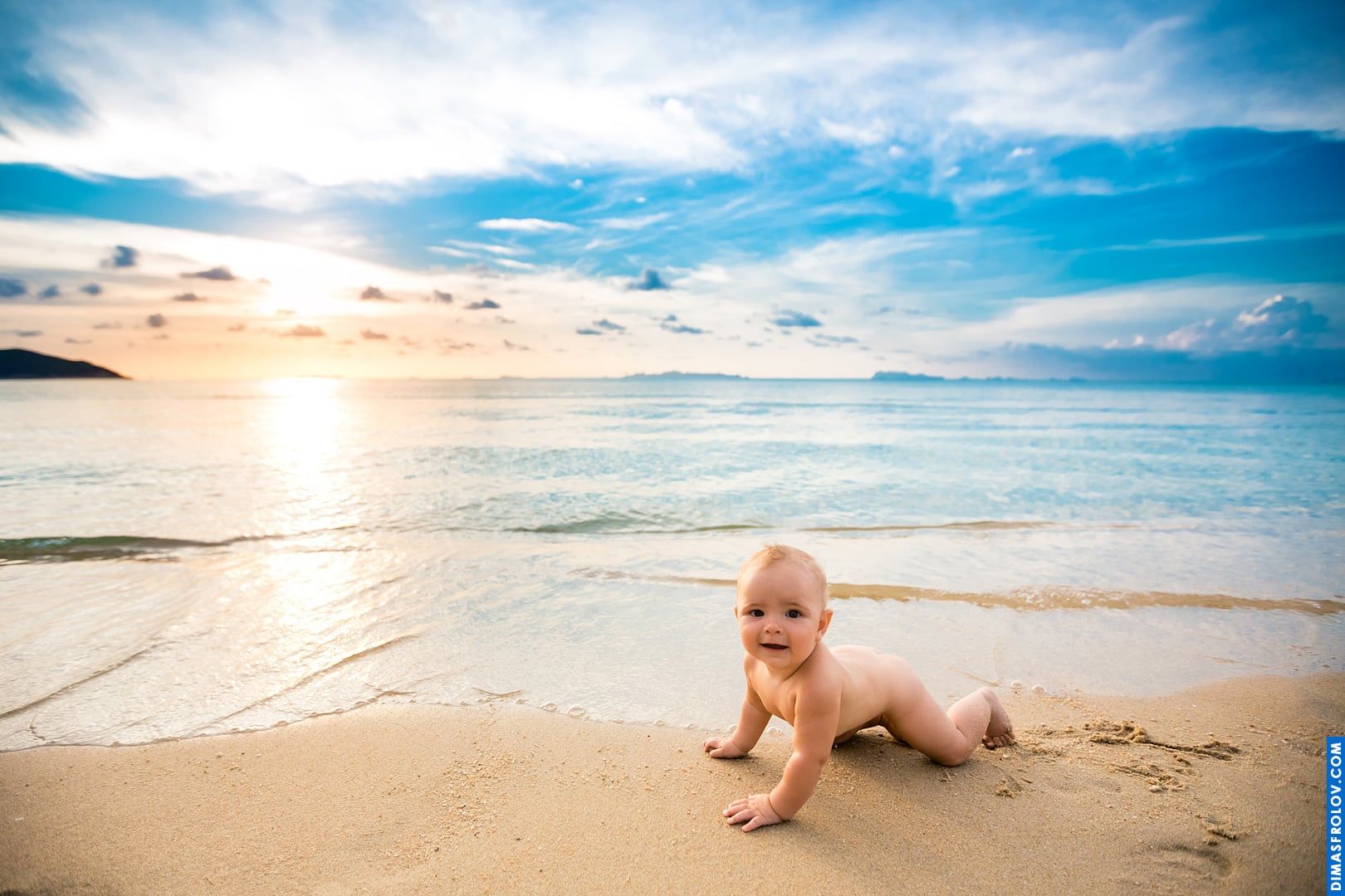 Sessão de fotos de bebê na praia — sentado calmamente na areia ao pôr do sol