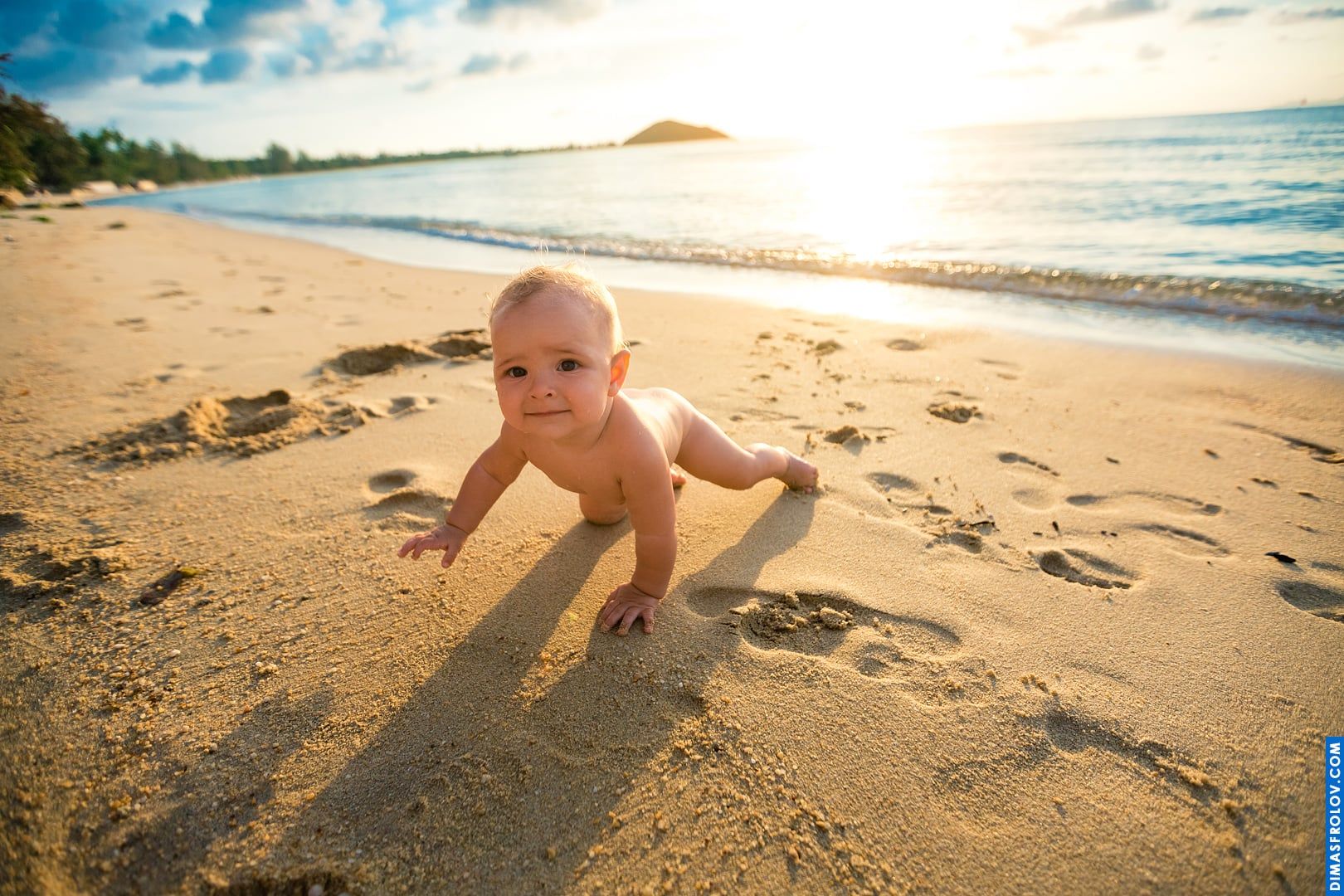 Bebê engatinhando na praia ao pôr do sol — luz dourada e mãos pequenas