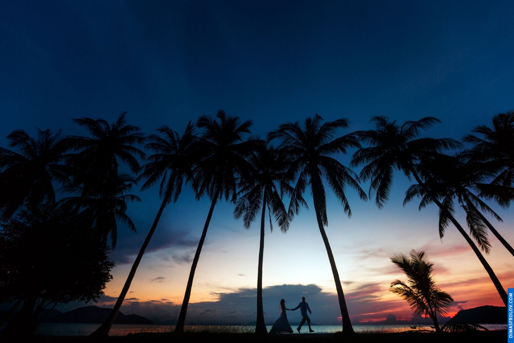 Wedding couple walking under palm silhouettes at sunset — cinematic beach photoshoot