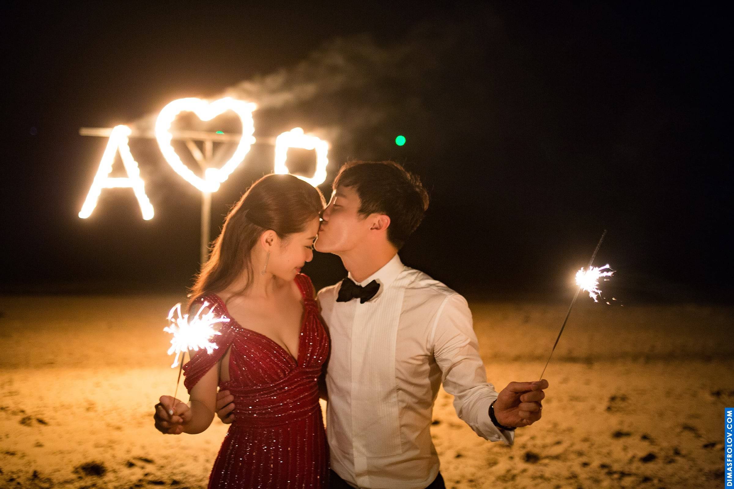คู่แต่งงานเล่นดอกไม้ไฟในยามค่ำคืน