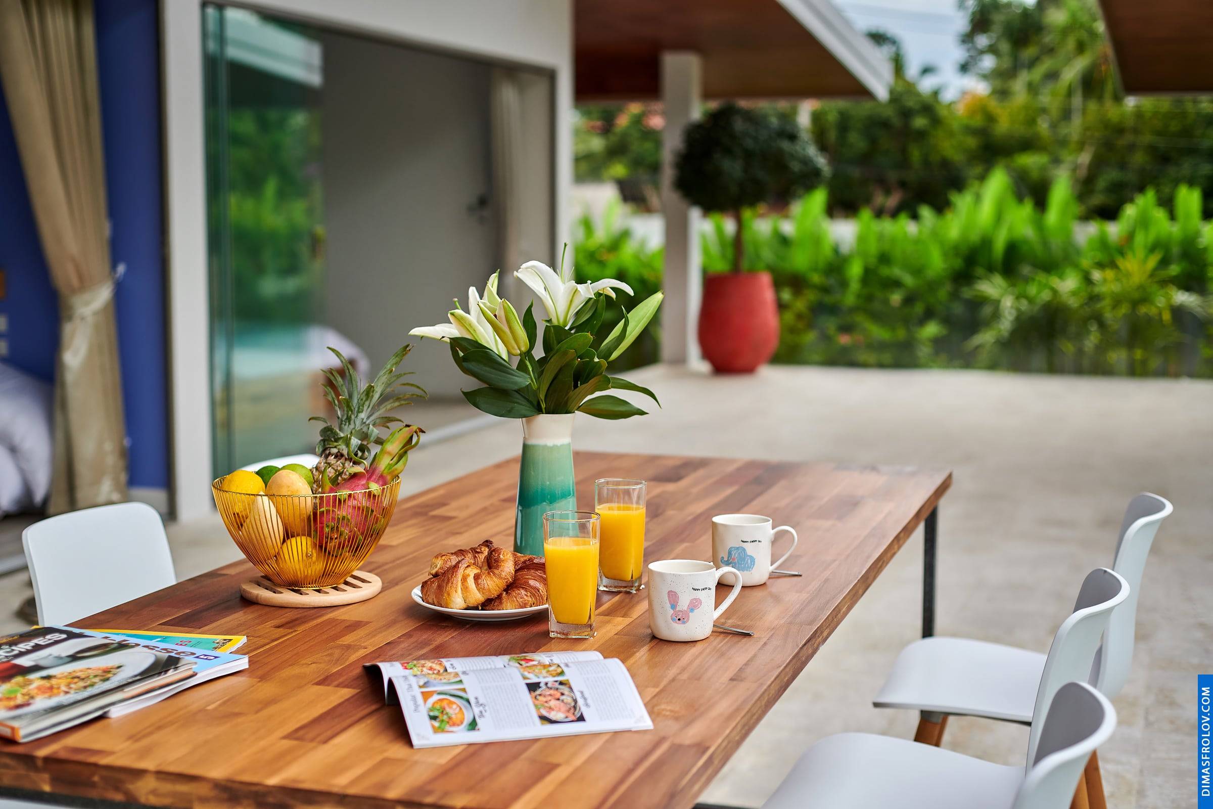 Hotel breakfast setting: elegant table with fresh food and tropical garden view