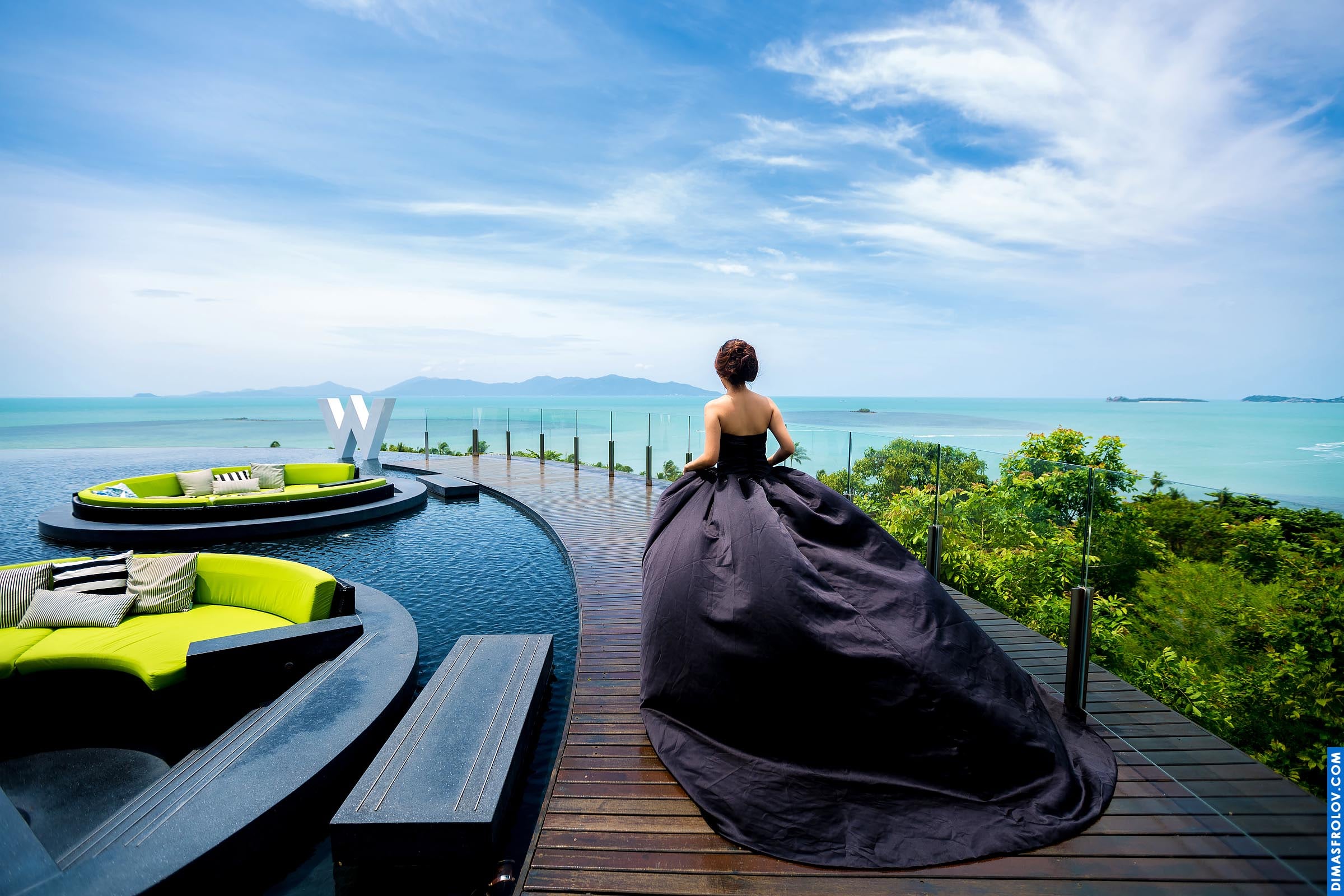 Woman in a dramatic black dress on a modern terrace with sea view