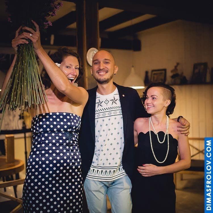 Birthday celebration at restaurant — happy guests posing with flowers and hugs
