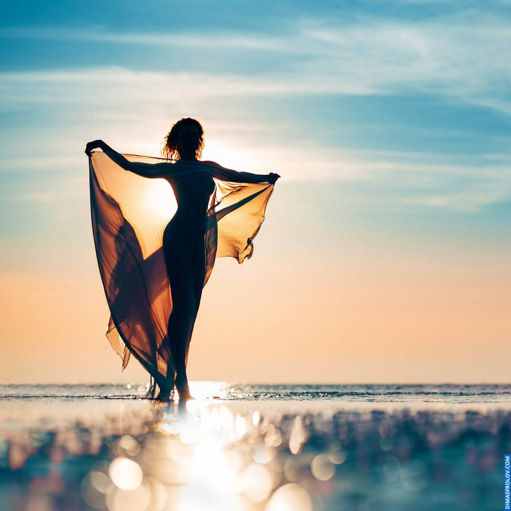 Woman-s silhouette at sunset during a fashion photo shoot