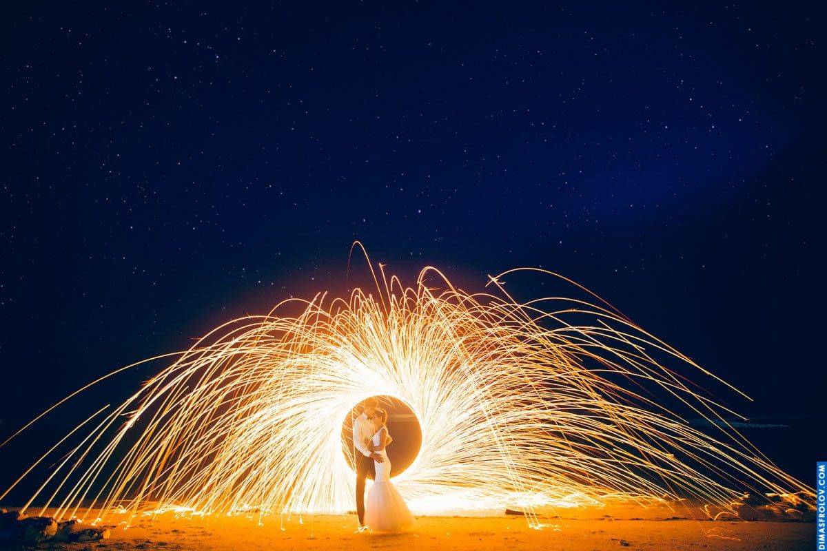 Night wedding kiss with steel wool sparks — cinematic and magical effect