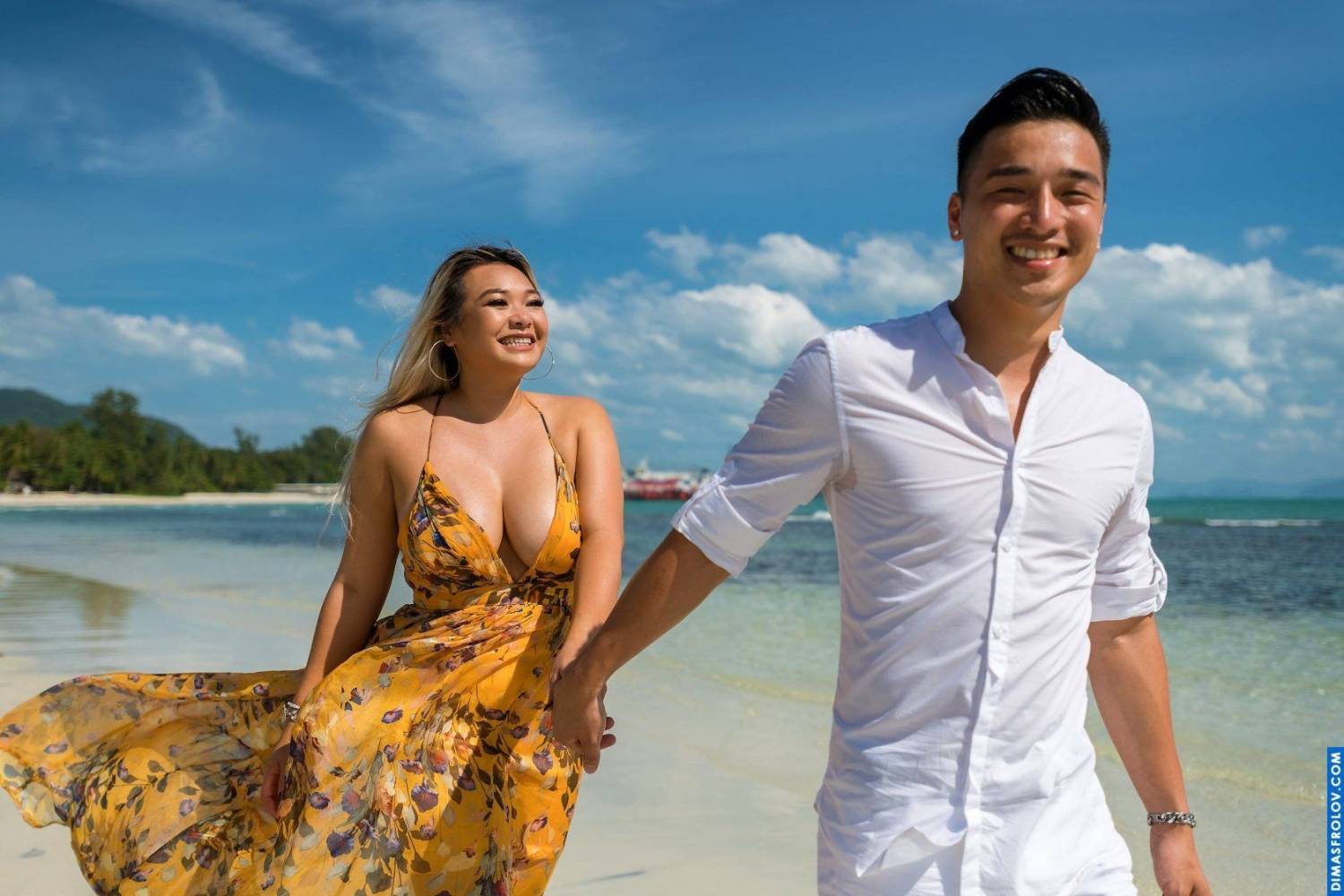 Playful couple session walking barefoot along the shoreline