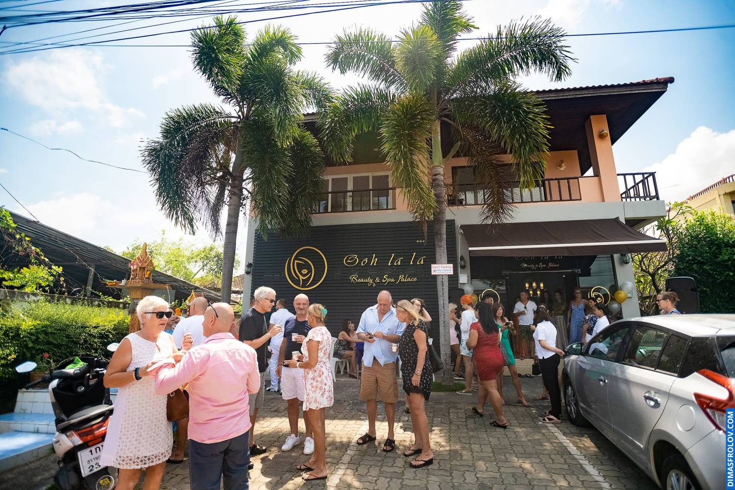 Crowd gathering in front of spa building for official grand opening ceremony