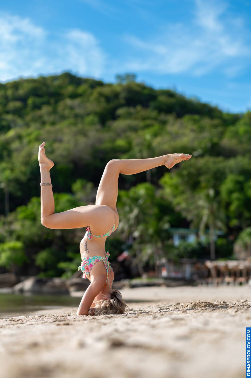 Inversion yoga pose on sandy beach — strength and balance in Pincha Mayurasana