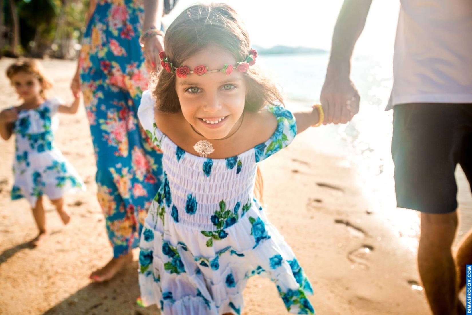 Candid family photo of a smiling girl during a beach photo shoot — natural and joyful moment