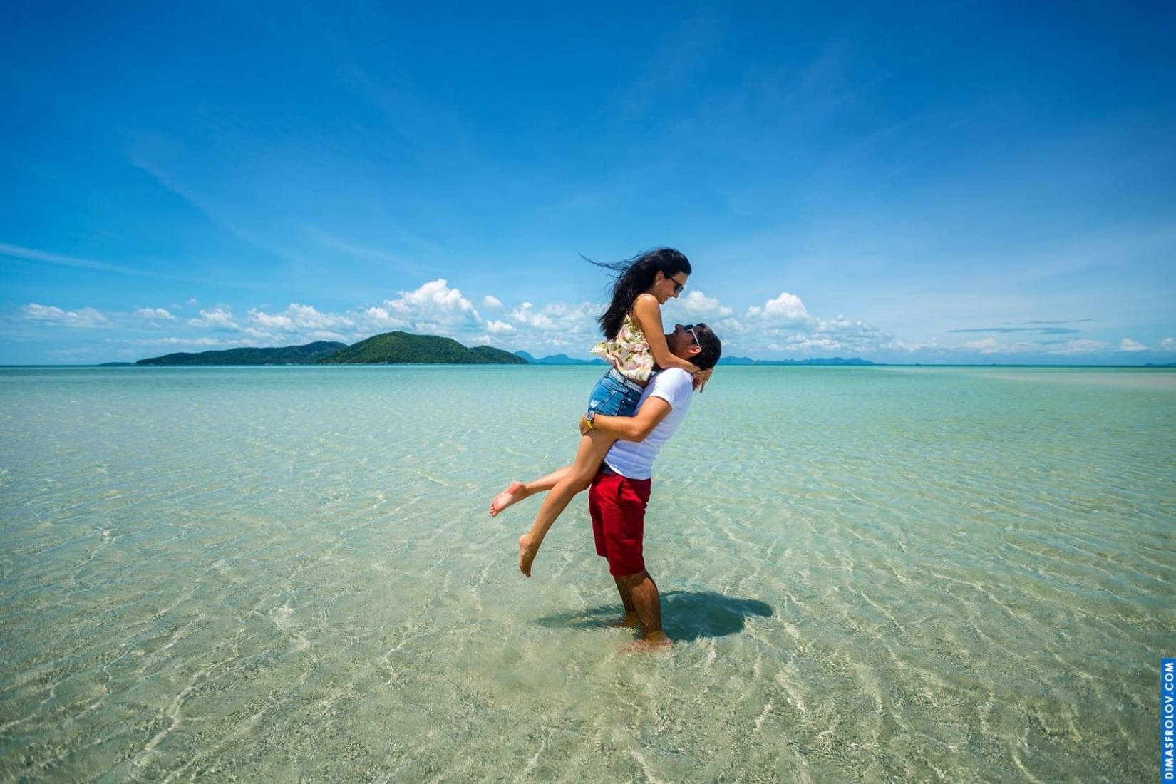 Intimate engagement photo in crystal-clear shallow water
