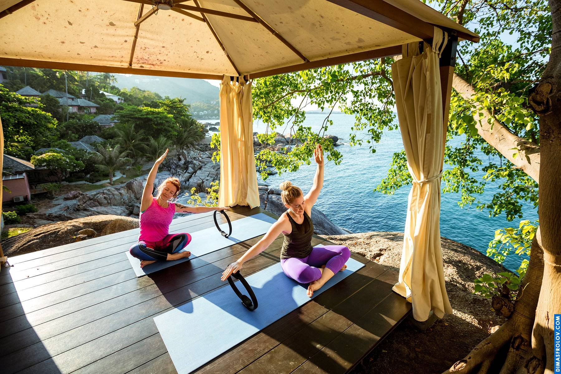 Relaxed partner yoga: two women in a supported seated pose outdoors