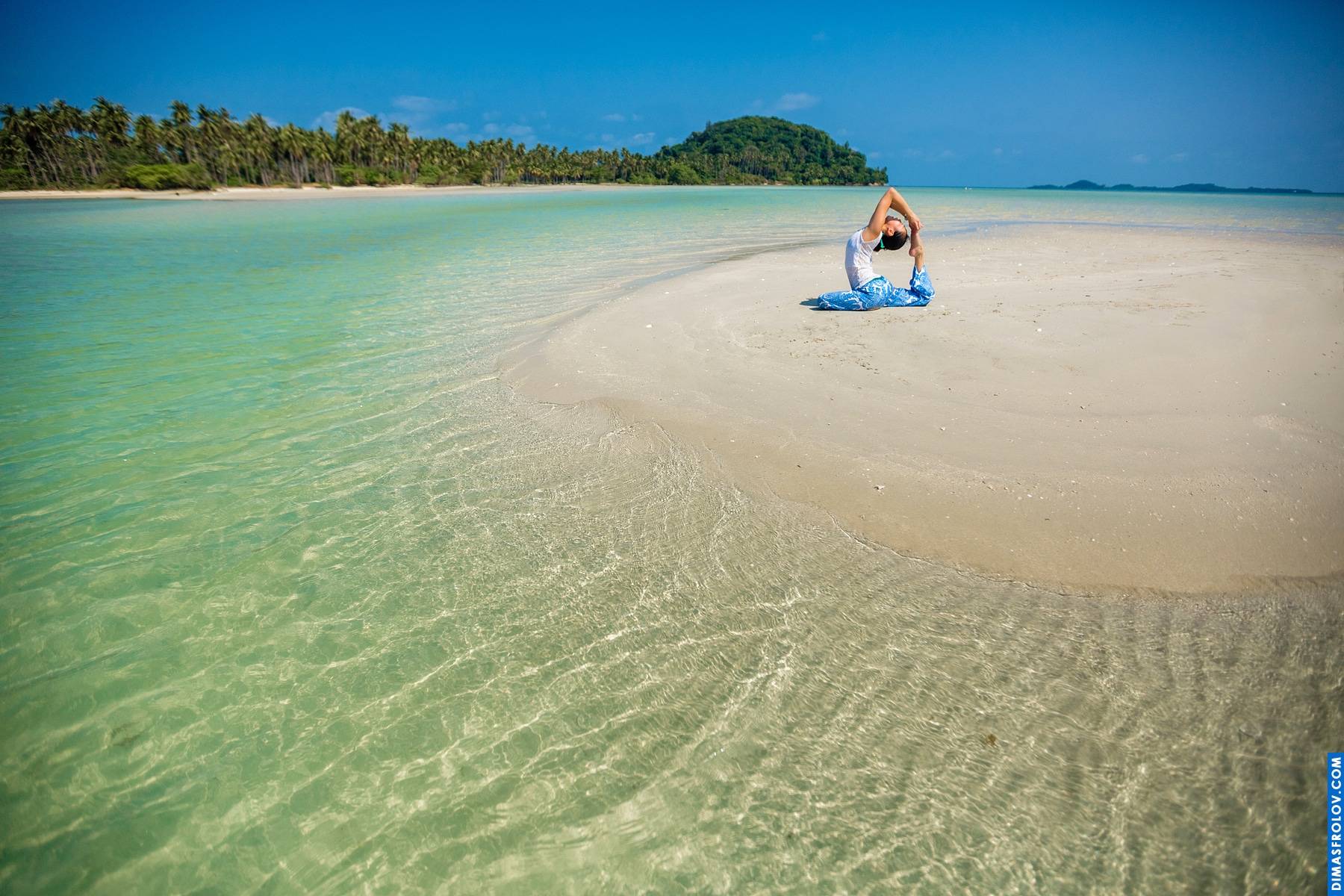 Tropical beach scene: serene turquoise water and white sand with a distant figure