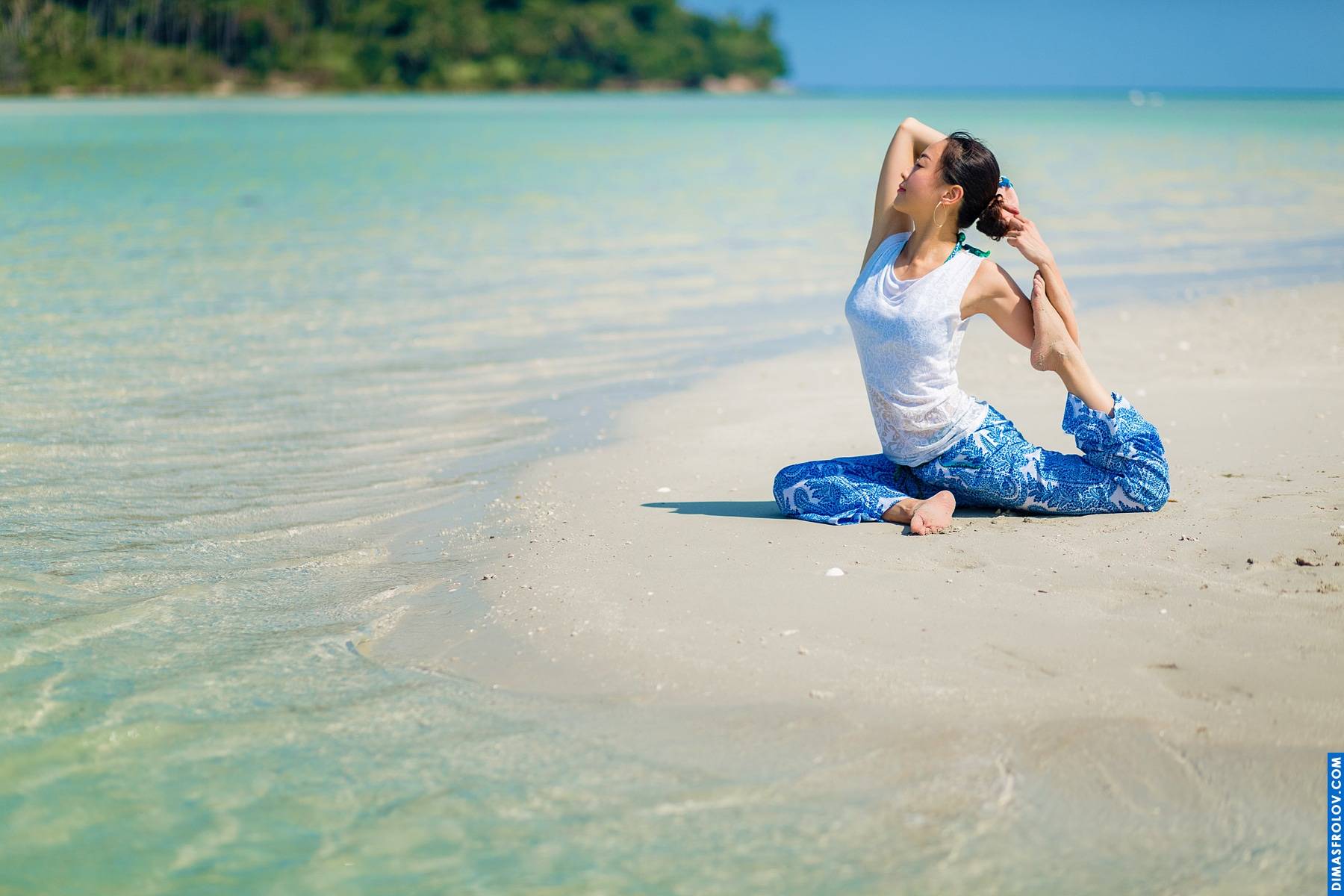 Relaxing beach yoga: woman in a seated pose with a serene ocean backdrop